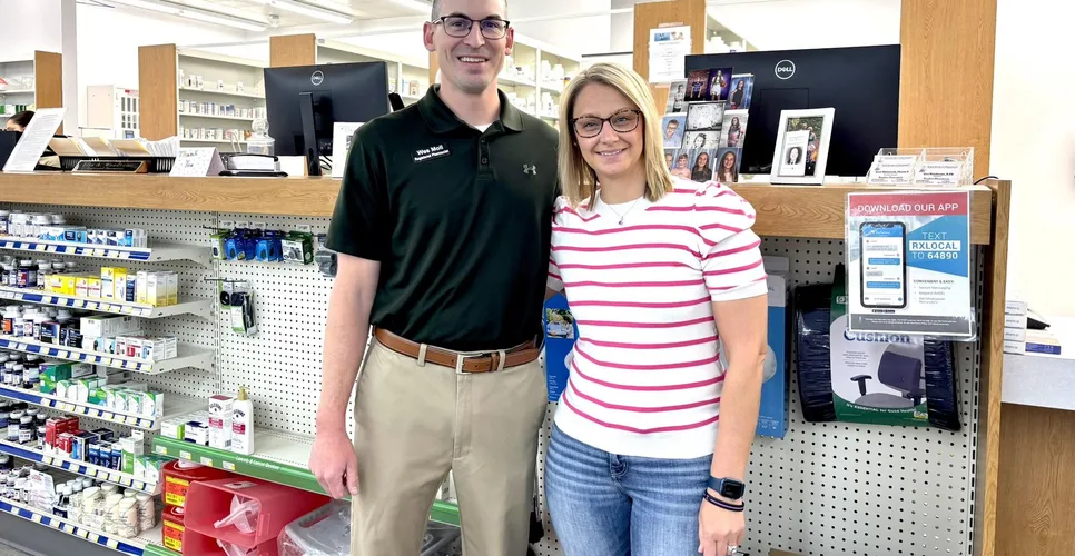 Wes Moll, Registered Pharmacist, and Jessi standing together at the pharmacy counter